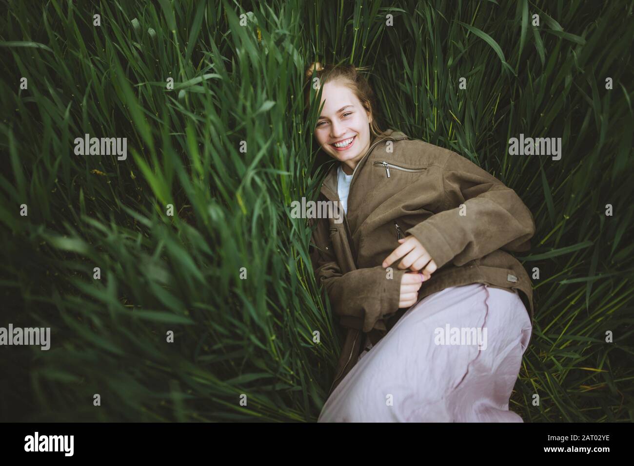 Lächelnde Frau im Gras liegend Stockfoto