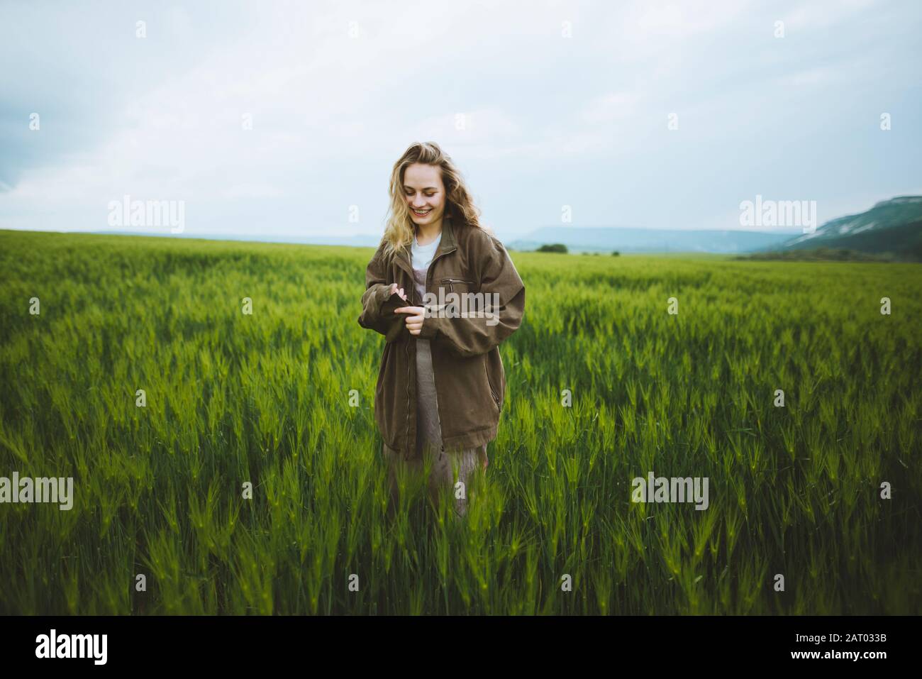 Lächelnde Frau trägt Jacke auf dem Feld in Krim, Ukraine Stockfoto