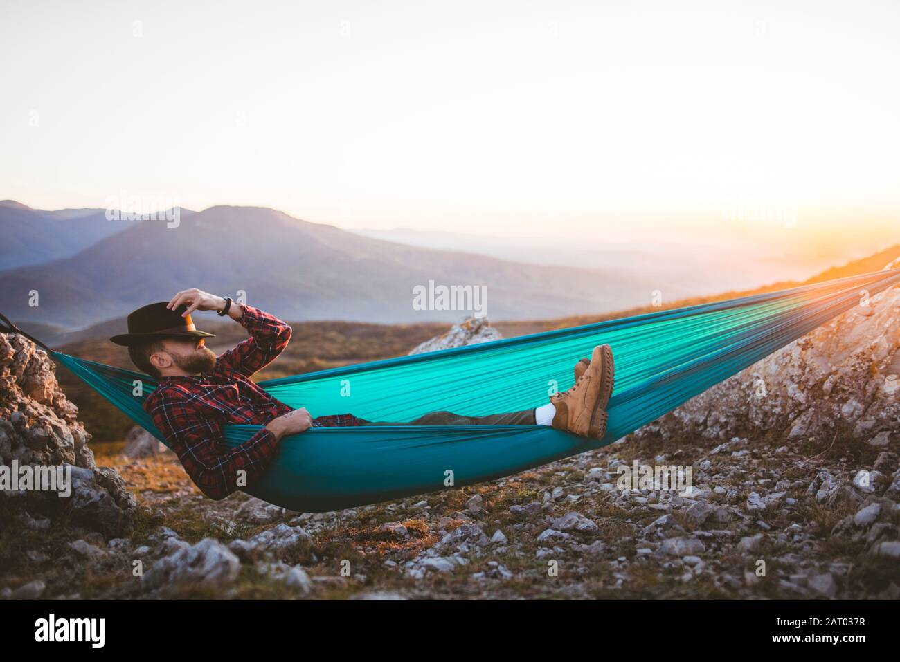 Mann, der in der Hängematte in der Bergkette schläft Stockfoto