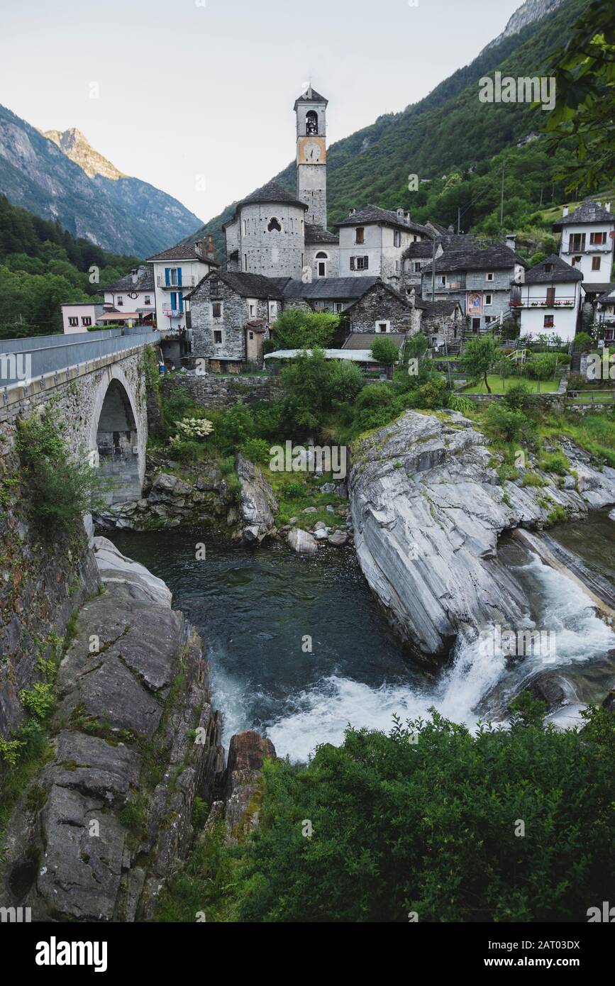 Glockenturm durch Brücke und Fluss im Tessin, Schweiz Stockfoto