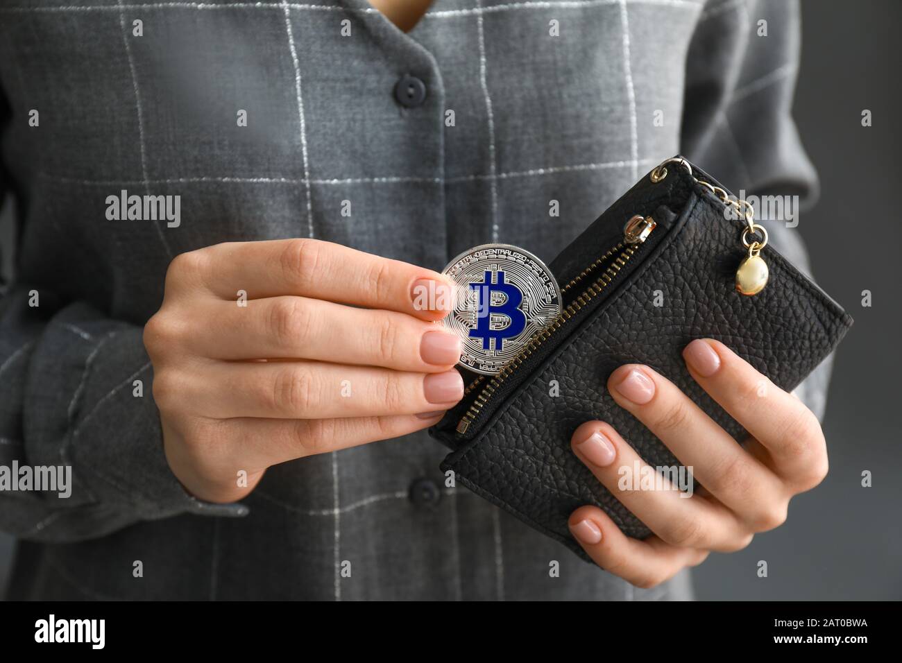 Frau, die Bitcoin aus der Brieftasche herausnimmt, Nahaufnahme Stockfoto