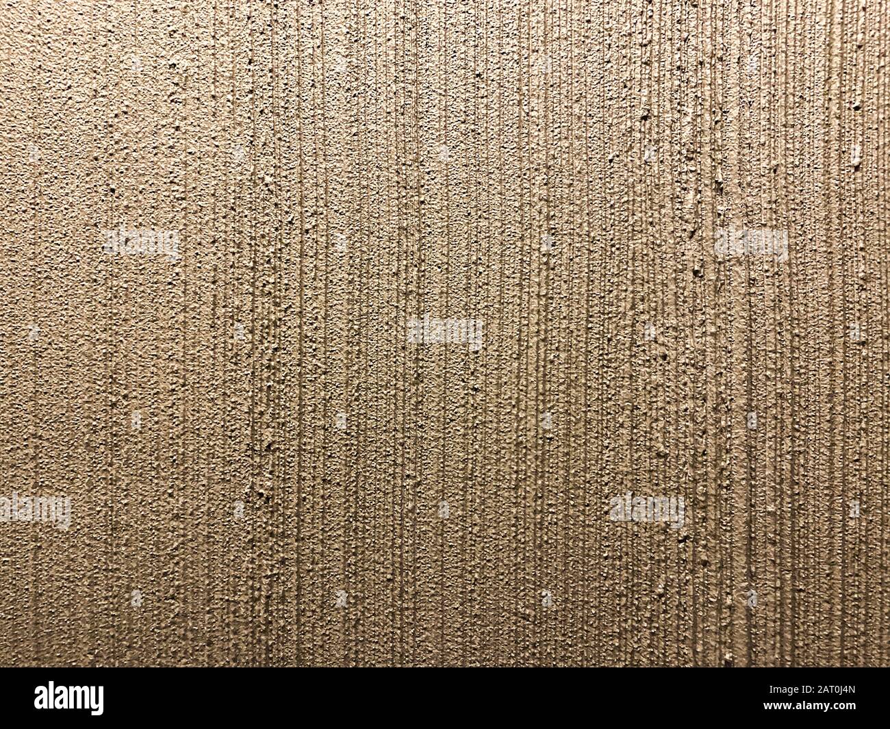 Textur der körnigen, verputzten Innenwand. Bronzefarbener gestreifter Putzhintergrund Stockfoto
