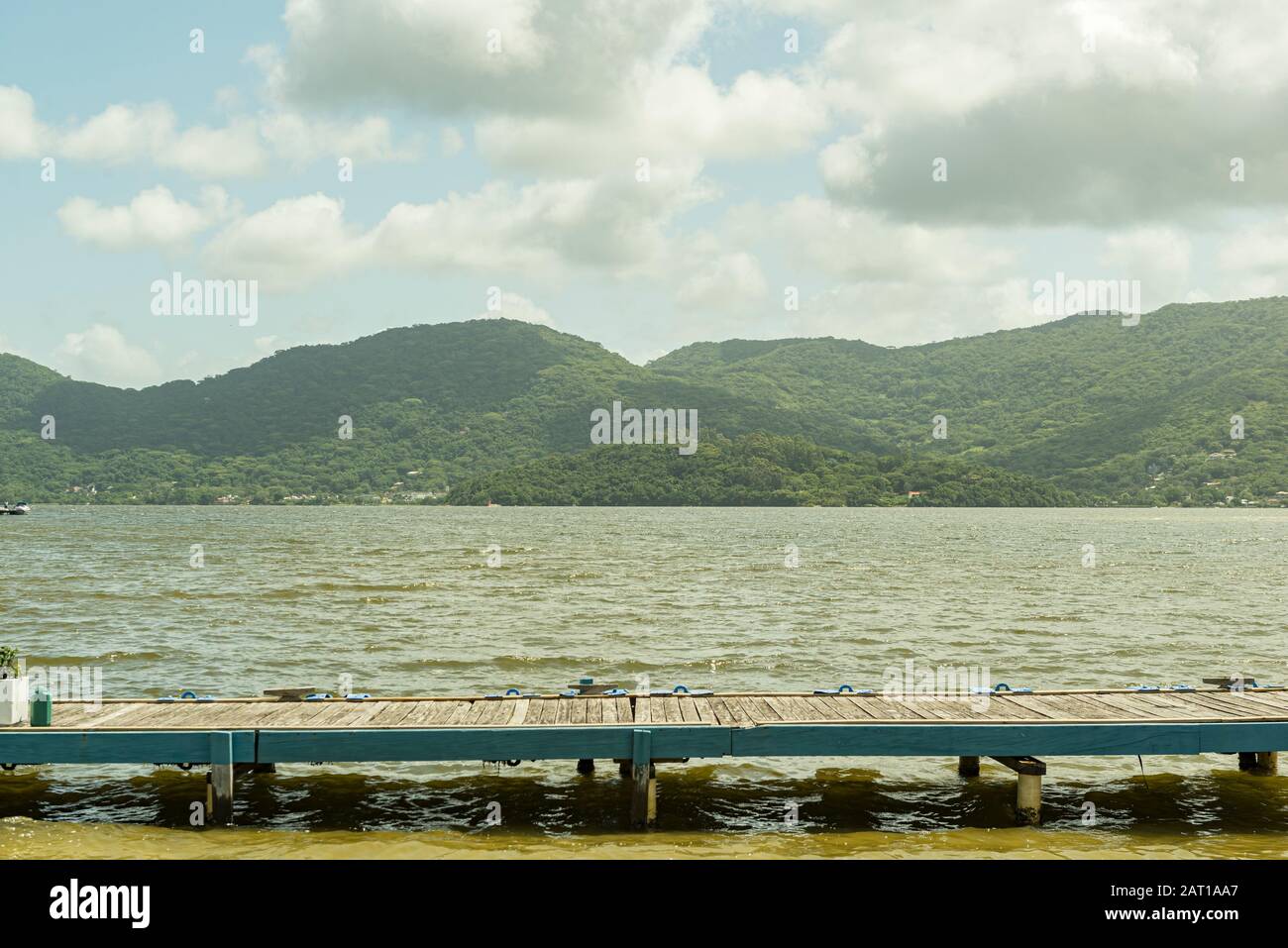 Holzsteg am See Lagoa da Conceição in Florianopolis, Brasilien. Mit schöner Landschaft von Bergen im Hintergrund. Stockfoto