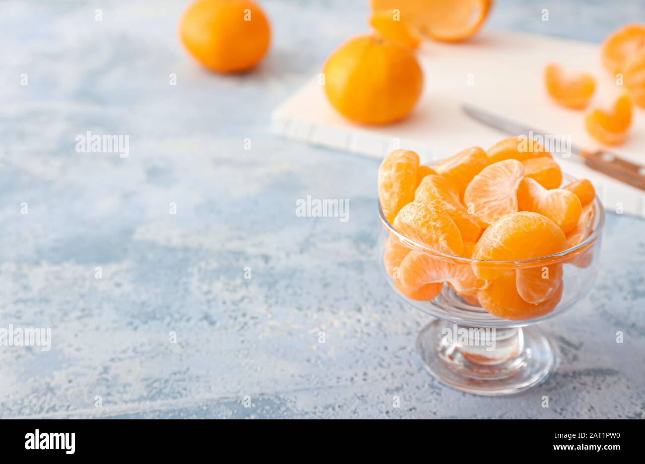 Dessertschüssel mit süßen Tangerinsegmenten auf Farbhintergrund Stockfoto