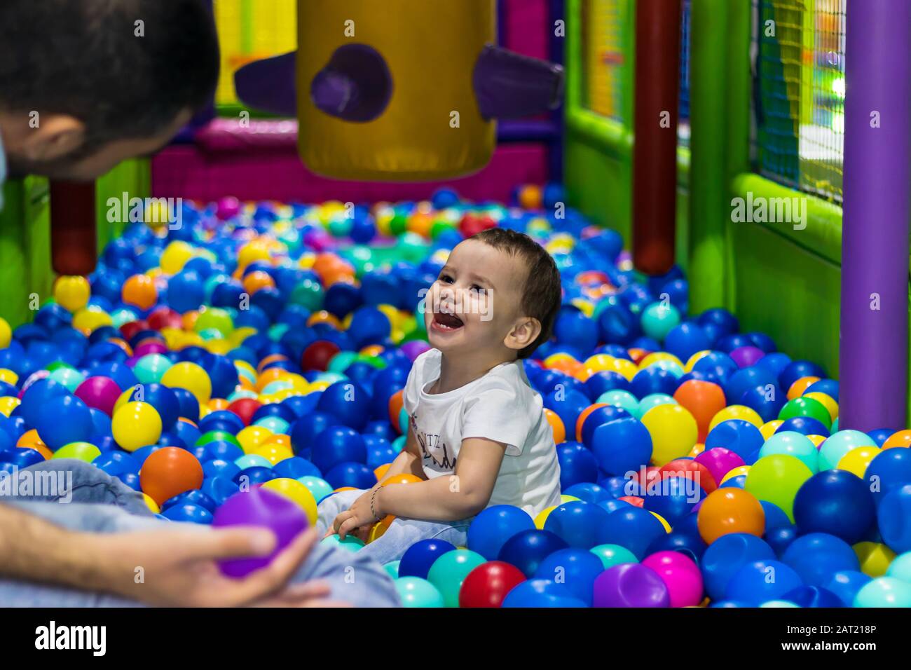 Ein süßes und glückliches kleines Mädchen, das auf einem Indoor-Spielplatz in einem Einkaufszentrum in Dubai, Vereinigte Arabische Emirate lachen und spielt. Stockfoto