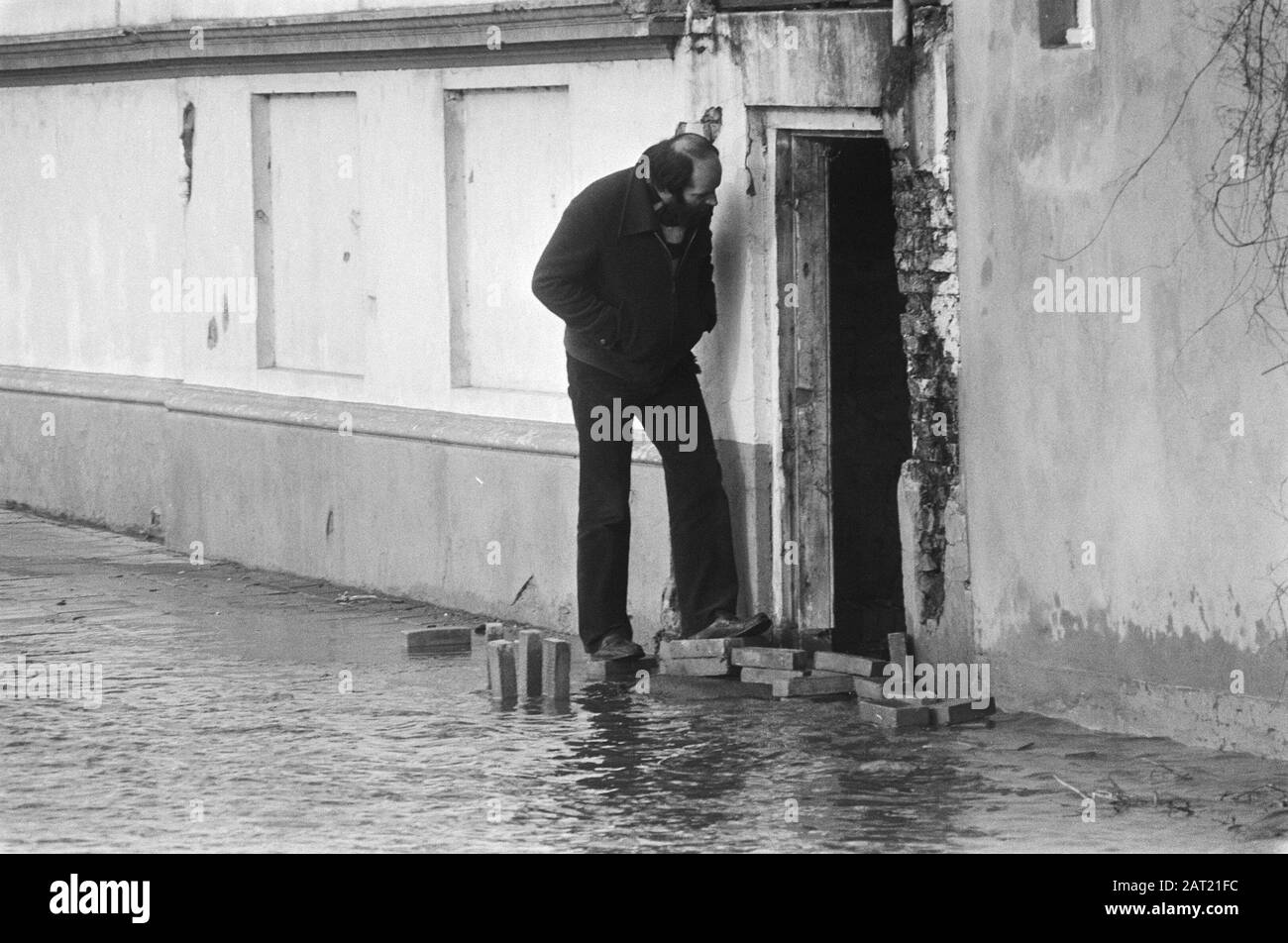 Wasserbelastung durch Schmelzen und Regenwasser. Mann im Haus in der überfluteten Straße Datum: 8. Januar 1982 Schlagwörter: WATEROUND Stockfoto