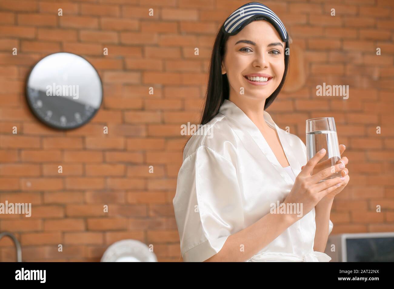 einer schönen jungen Frau mit einem Glas Wasser in