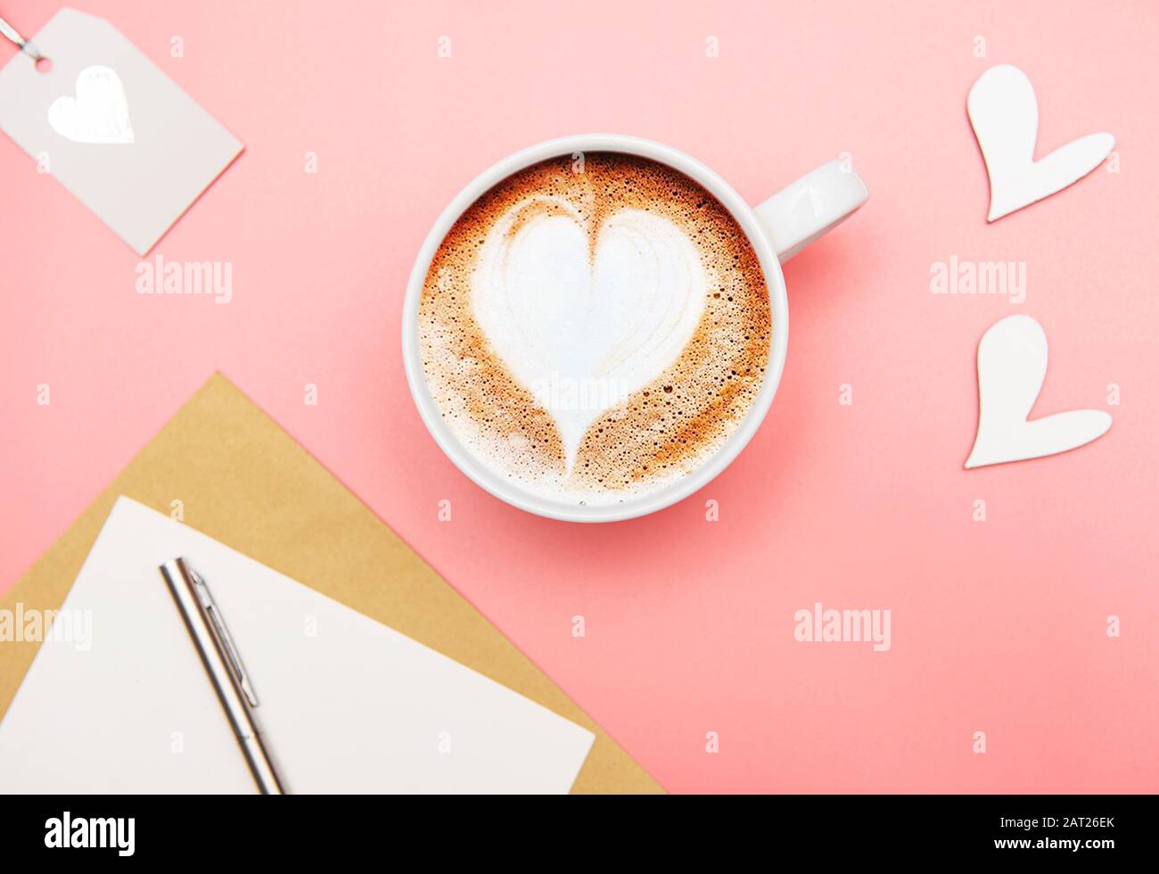 Tasse Kaffee Latte mit Herzform und Valentinen-Deko auf pinkfarbenem Hintergrund Stockfoto