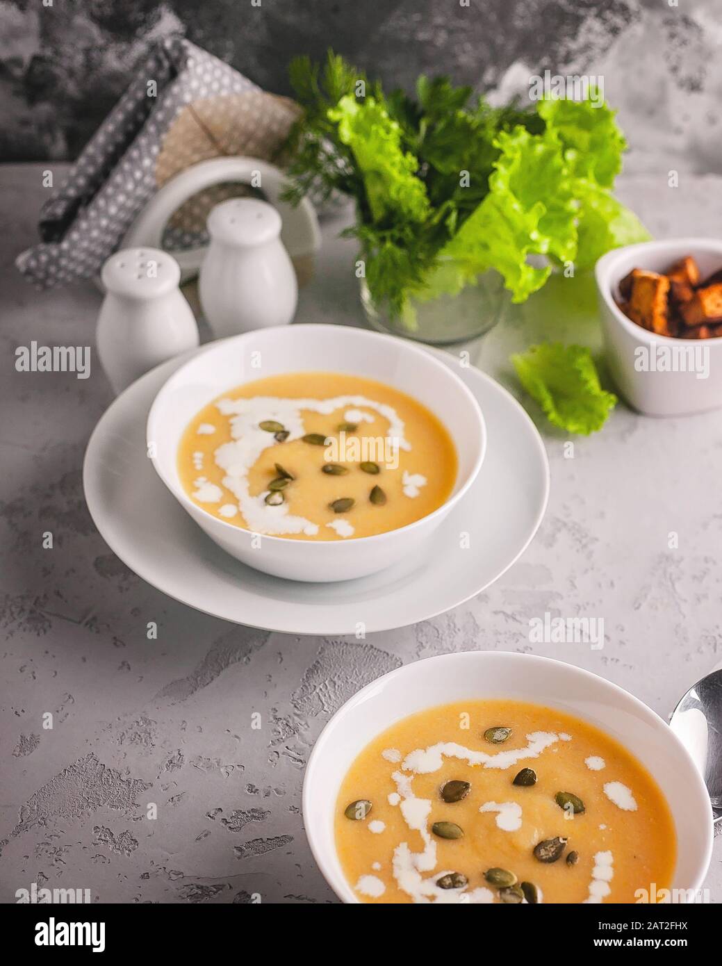 Gemüsesuppe mit Sahne und Kürbissamen in weißen Platten. Gesunde und leckere Speisen. Stockfoto