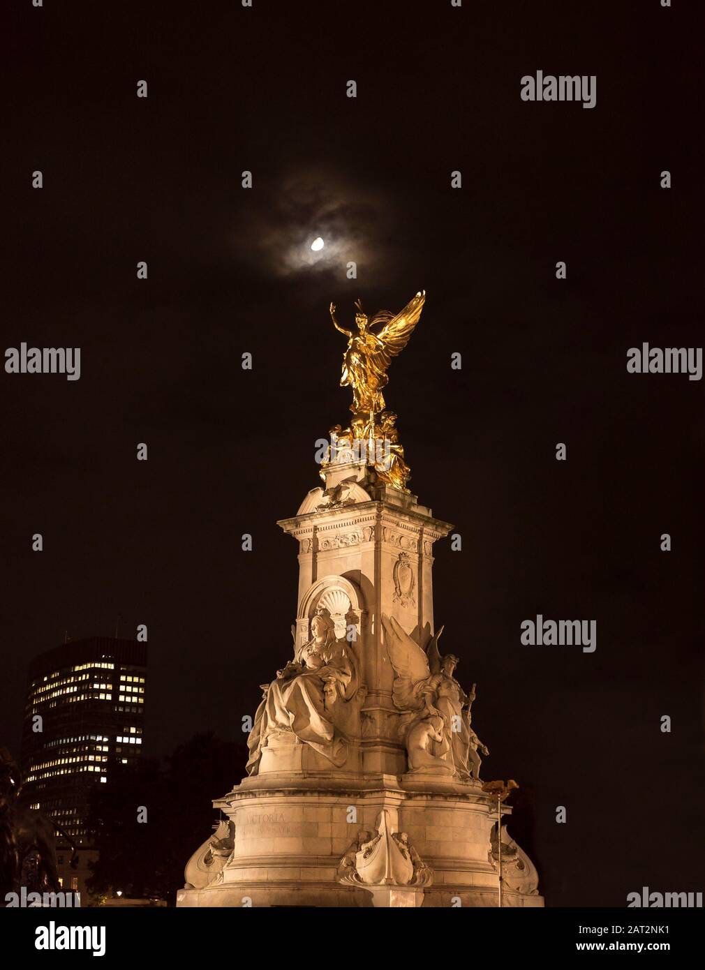 Niedriger Winkel Nachtansicht, Königin Victoria Gedenkstatue vom Buckingham Palace beleuchtet, isoliert in dunklem Himmel; Winged Victory Statue scheint in Mondlicht. Stockfoto