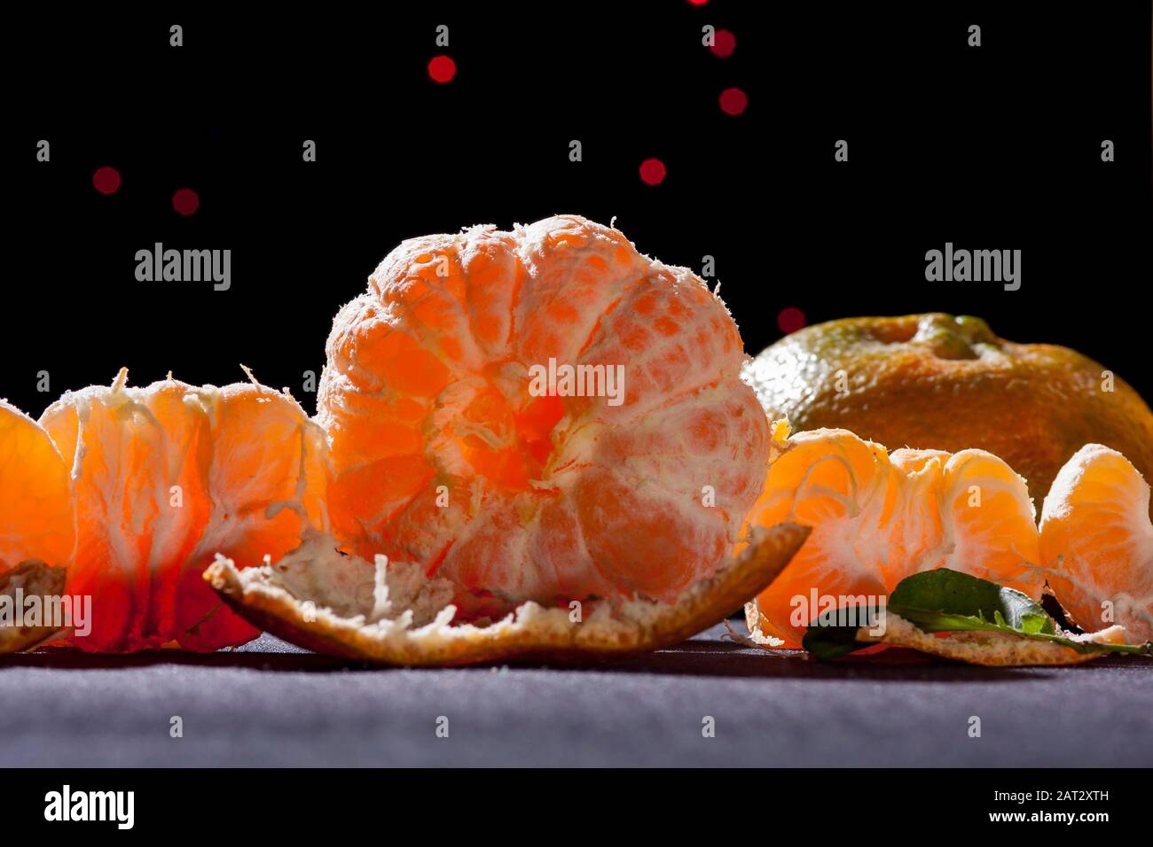 Orangen Tangerin, Zitrusreticula. Auf dem Tisch mit schwarzem Hintergrund und Hintergrundbeleuchtung Stillleben .Mandarinsorte Orange enthält Pomelo und c Vitamin. Stockfoto