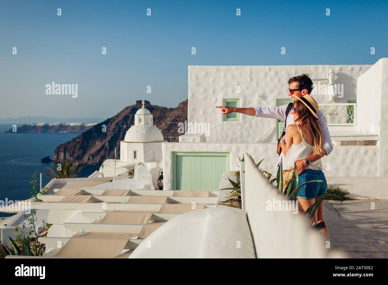Santorini Urlaub, Griechenland Flitterwochen. Ein Paar, das gerne in Fira spazieren geht. Mann und Frau genießen Meereslandschaft. Stockfoto Santorini Urlaub, Griechenland Flitterwochen. Ein Paar, das gerne in Fira spazieren geht. Mann und Frau genießen Meereslandschaft. Stockfoto