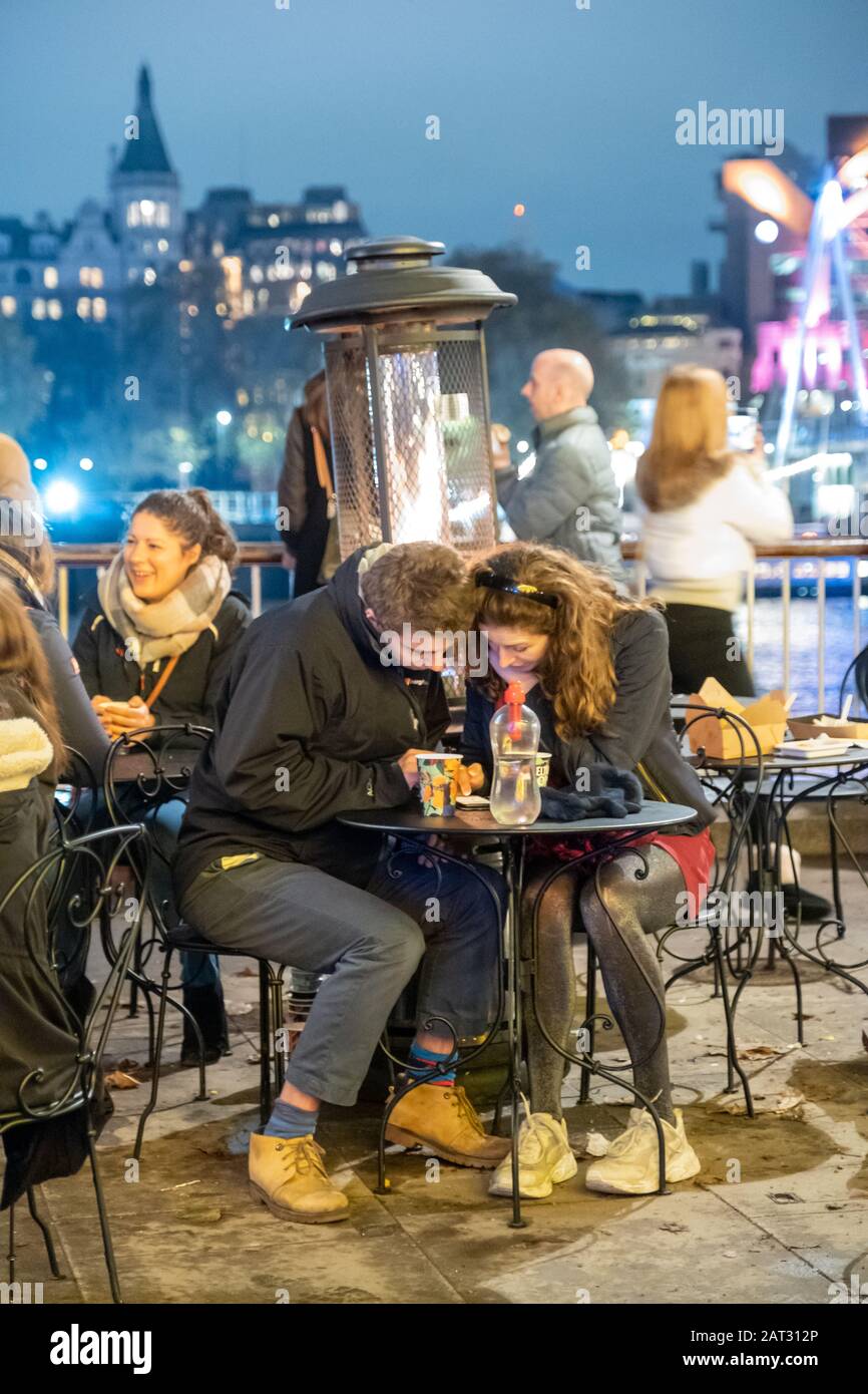 London/Großbritannien - 24. November 2019: Paar sitzt am Außentisch des Straßencafés in South Bank in London, Großbritannien Stockfoto