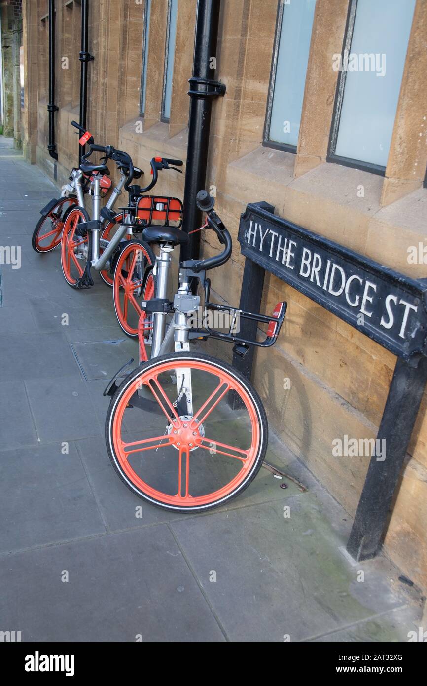 Mobikes in Oxford zu mieten: Ihre Fahrräder sind in glänzendem metallischem Silber mit ungewöhnlichen orangefarbenen Rädern. Stockfoto