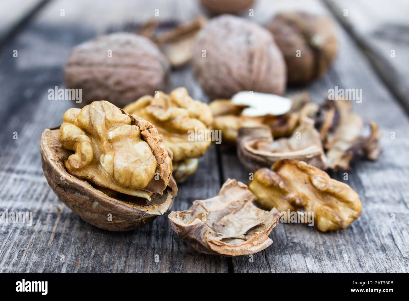 Geschälte Walnüsse und Nusskernel liegen auf einem rustikalen alten Holztisch. Walnüsse ernten. Stockfoto