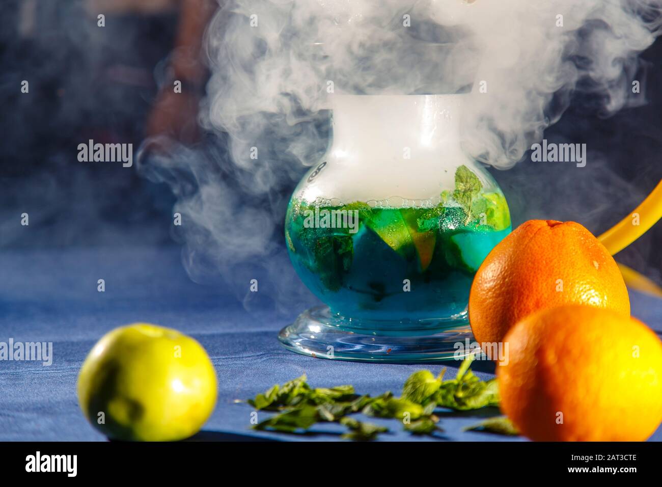 Hookah auf der Orange. Orange Hookah. Hookah mit einem runden durchsichtigen Kolben, in dem in Scheiben geschnittene Orangen und Minzblätter in roter Lauge schweben. Die Kapuzenbuge Stockfoto