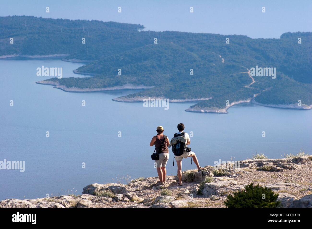 Ein Touristenpaar, das von Vidova Gora auf der Insel Brac auf die Insel Hvar blickt Stockfoto