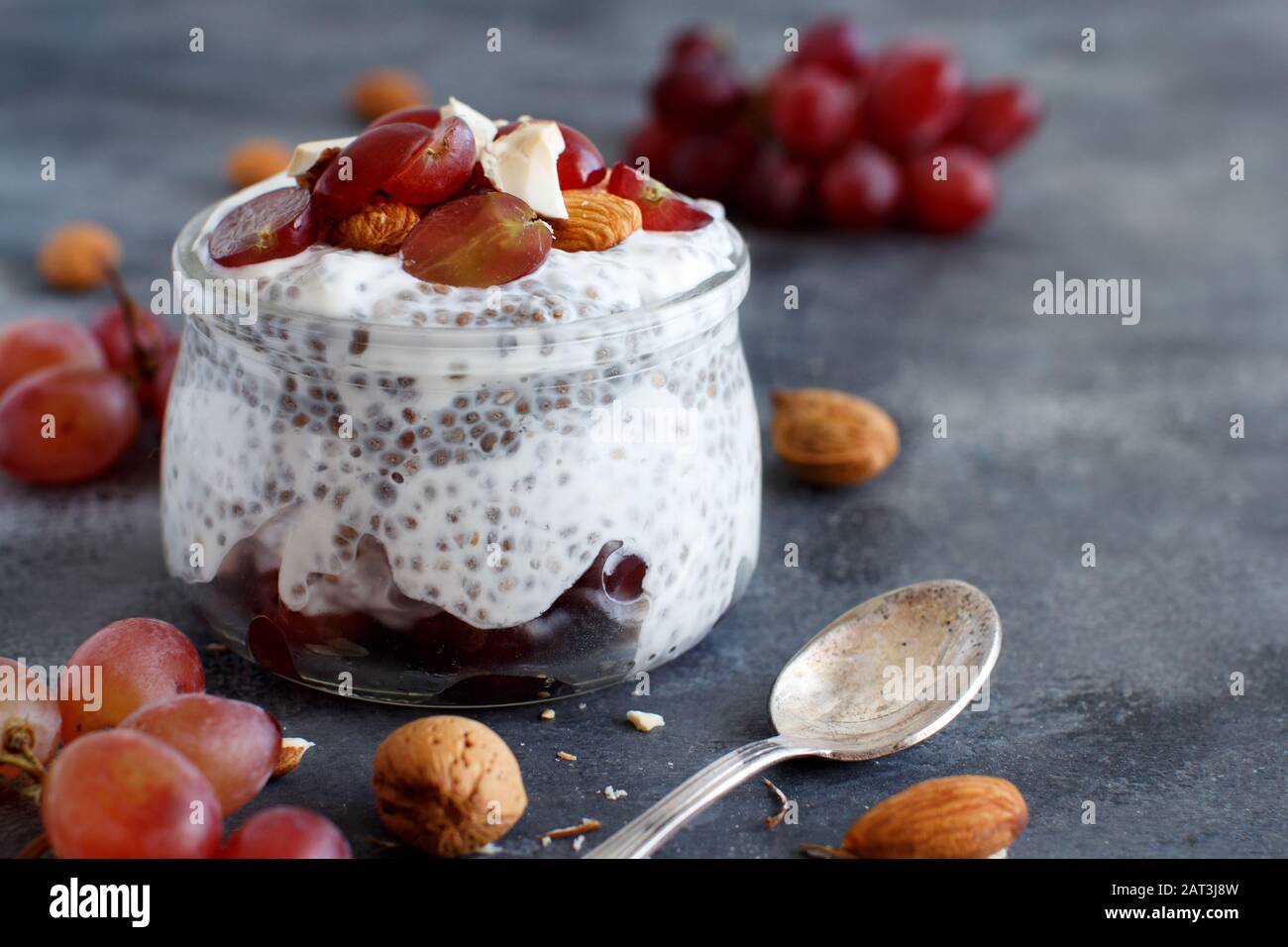 Chia Pudding-Parfait mit roten Trauben und Mandeln schließen sich an Stockfoto