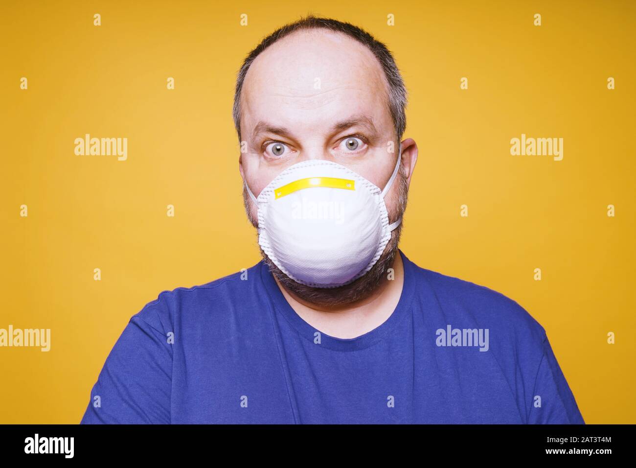 Mann mit Gesichtsmaske und Panik in seinen Augen - Konzept der Hysterie des Corona-Virus-Ausbruchs Stockfoto