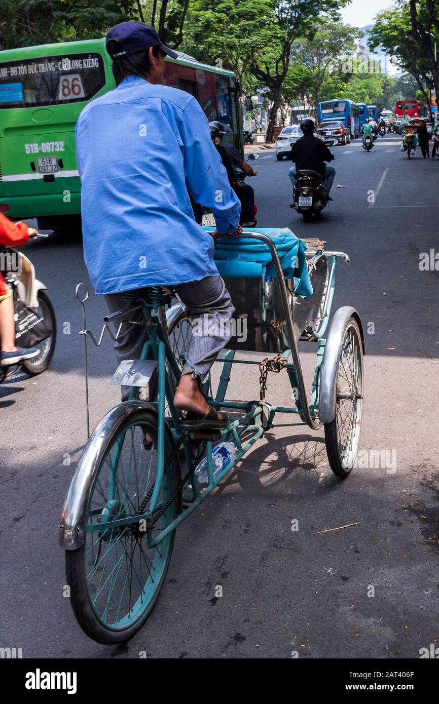 Radfahrer fährt auf der Straße hinunter, Ho-Chi-Minh-Stadt, Vietnam Stockfoto