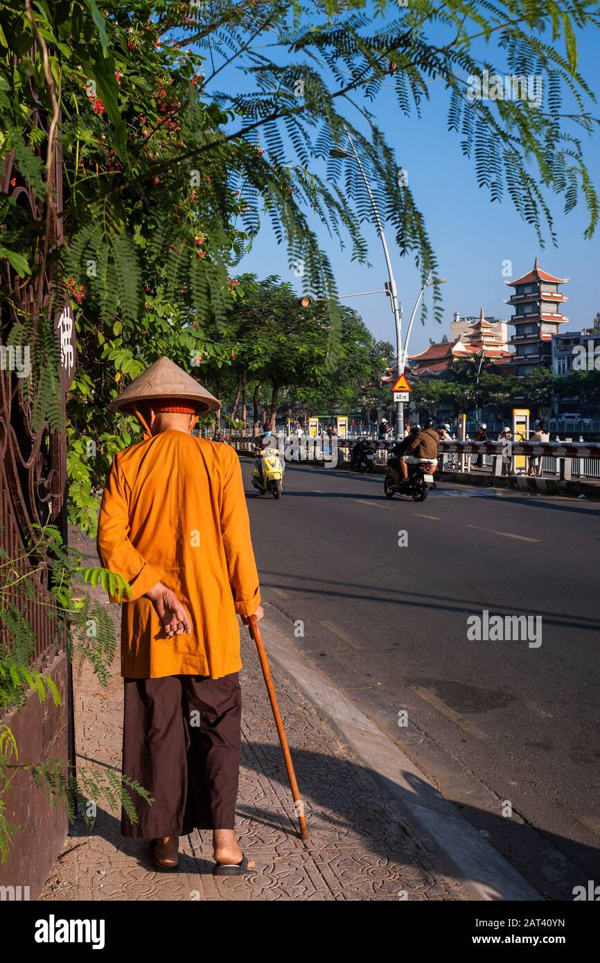 Älterer Mann, der mit einem Gehstock auf der Straße spazieren geht, Ho-Chi-Minh-Stadt, Vietnam Stockfoto