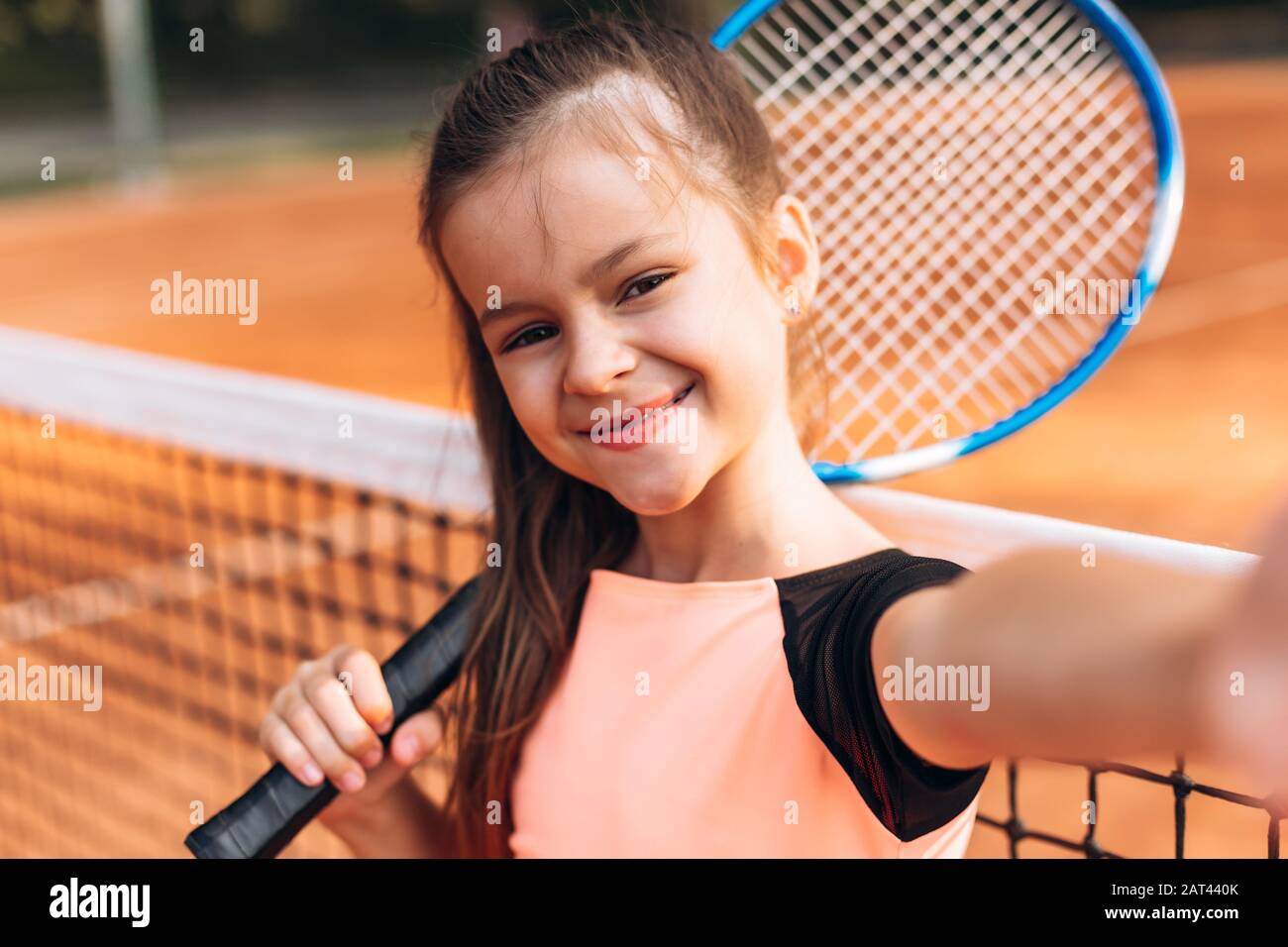 "ute, hübsches Mädchen, das ein selfie mit einem Schläger auf einem Tennisplatz nimmt. Stockfoto