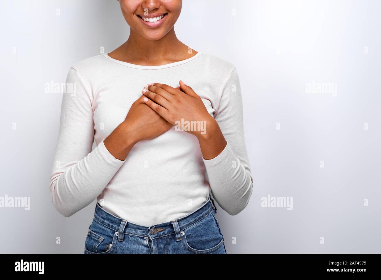 Das zupfende Bild einer süßen Mulatthofrau zeigt eine sanfte Geste der Liebe mit den Armen auf der Brust. Konzeptgestus Stockfoto