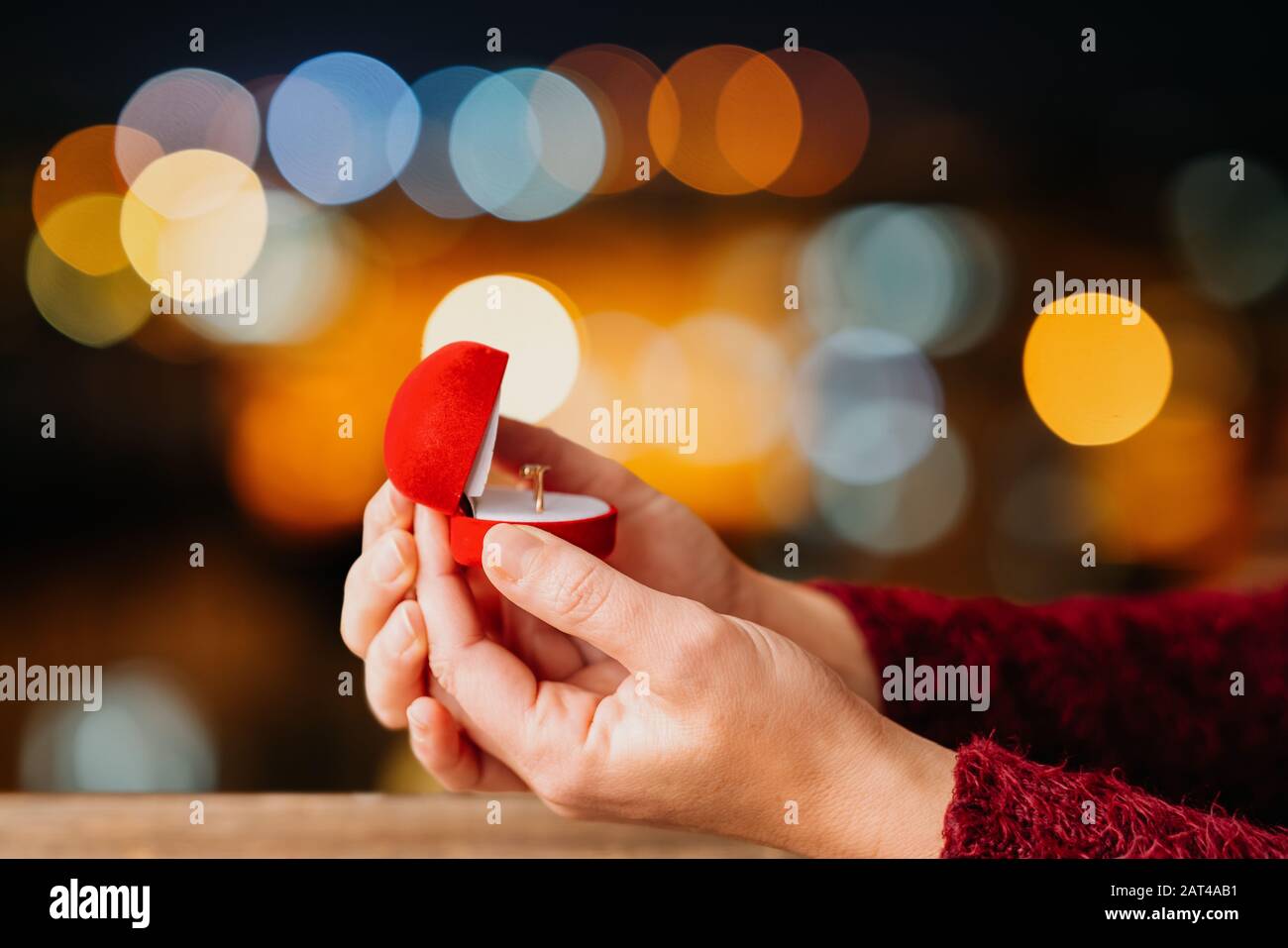 Frau öffnet ihren Schmuck für Geschenkschachtel mit Bokeh LED leuchtet Hintergrund. Valentines Tag- und Romanzkonzept Stockfoto