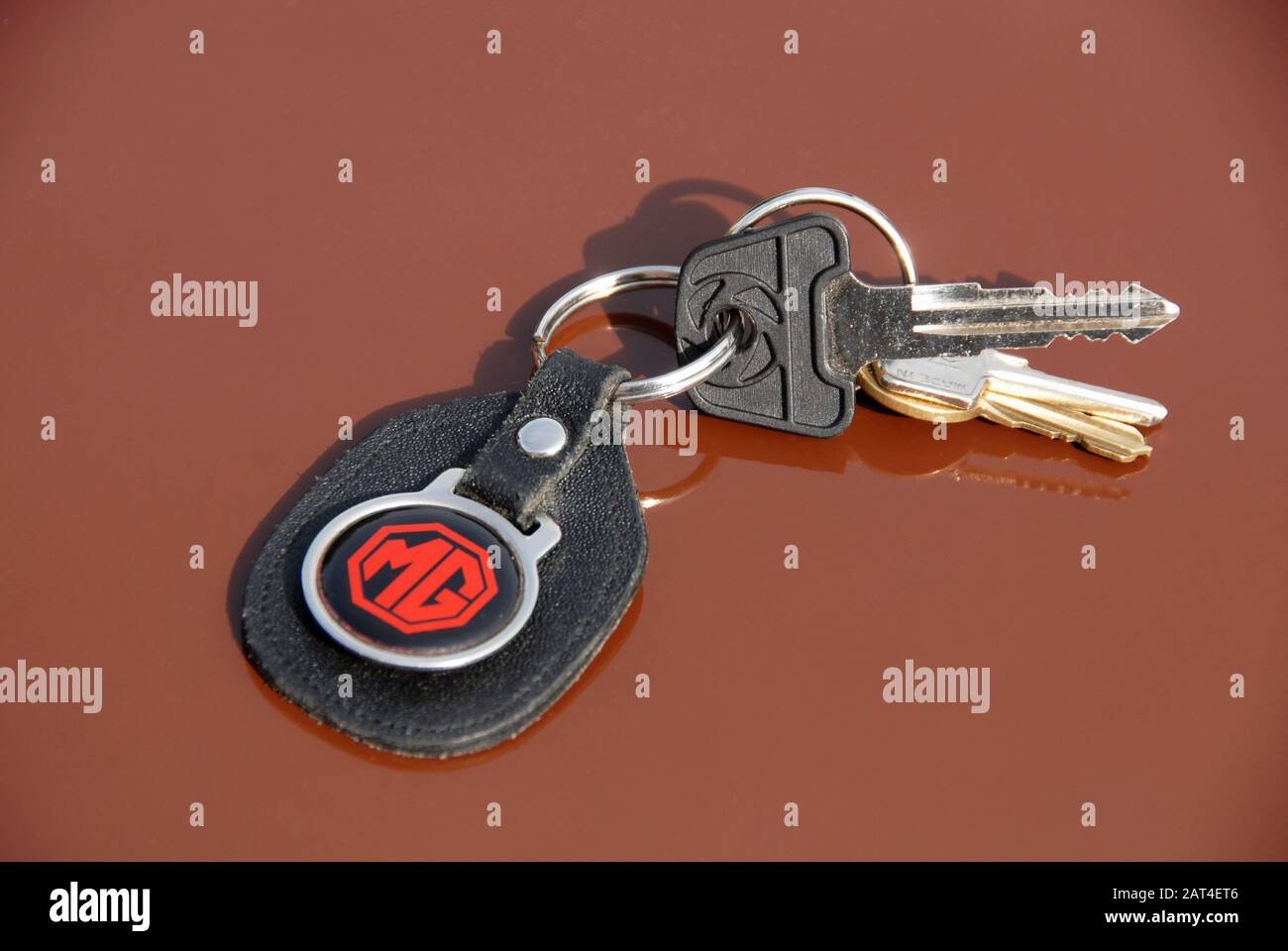 Schlüssel für MG Sportwagen auf Schlüsselring mit fob und MG-Logo, auf der Motorhaube des russet braunen MGB GT Stockfoto