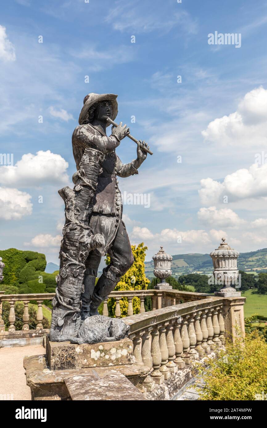 Statue des Mannes aus dem 18. Jahrhundert, der Flöte mit Hund spielt, Powis Castle, Powys, Wales, Großbritannien Stockfoto