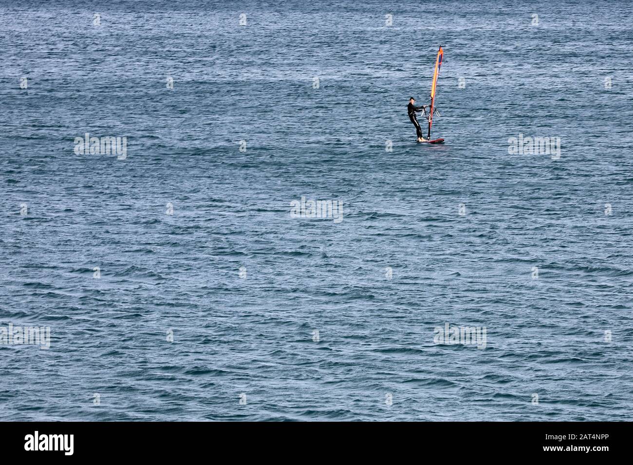 Eine Person, die allein Windsurf am Meer in Valencia macht. Stockfoto