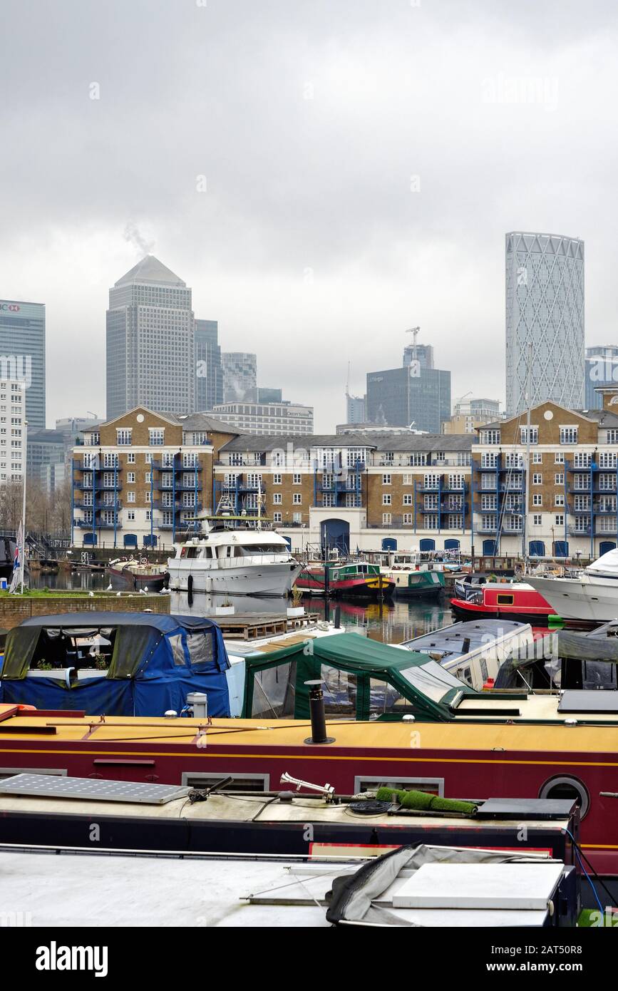 Boote in einem überfüllten Limehouse Basin mit den Wolkenkratzer-Gebäuden von Canary Wharf an der Skyline, Limehouse East London England UK Stockfoto