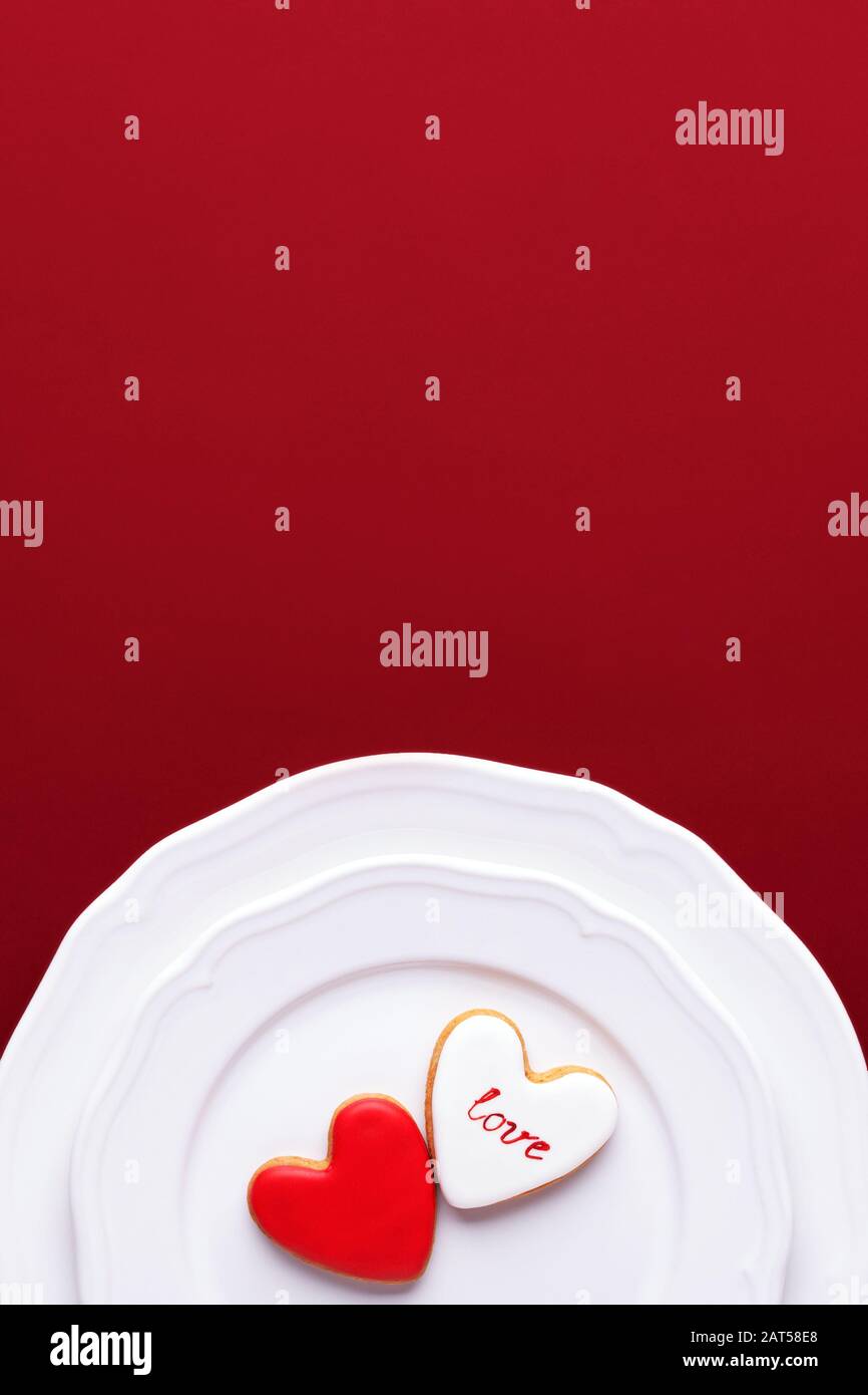 Zwei Valentinskekse in Form eines Herzens auf weißen Tellern. Top View, Konzept des Essens von Liebe. Stockfoto
