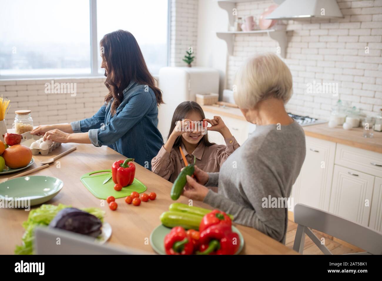 Mutter Großmutter und Kind bereiten Frühstück aus gesunden Bioprodukten vor. Stockfoto