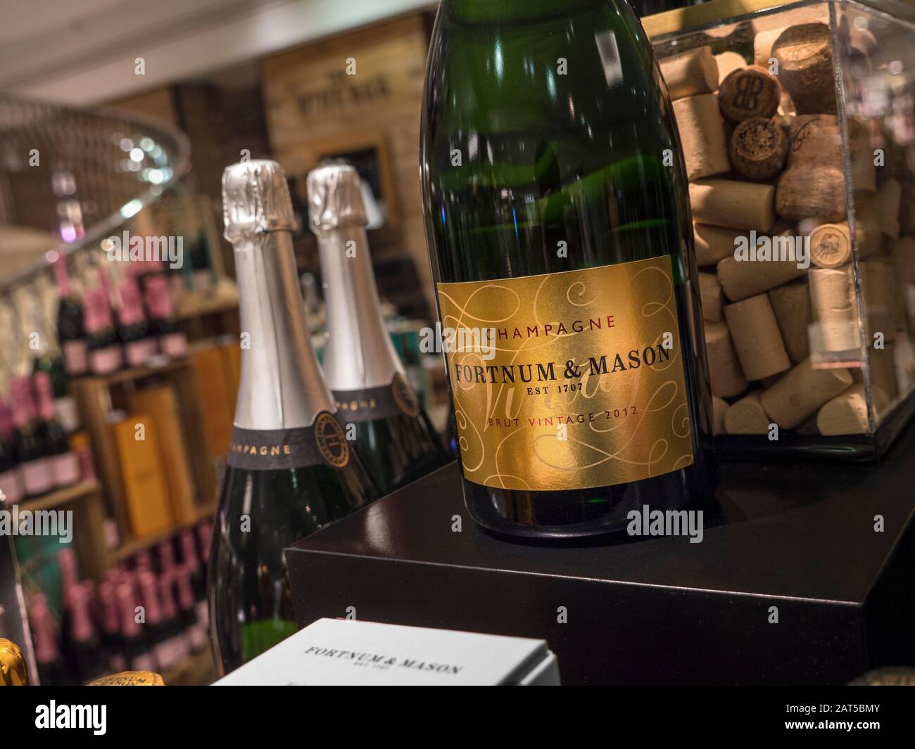 Fortnum & Mason Food & Drinks Hall mit luxuriöser Fortnum & Mason-eigener Brut Vintage 2012 Champagnerflasche mit hinterer Weinabteilung. Fortnum & Mason Food Hall Wine Department Piccadilly St. James's, London W1A 1er Stockfoto