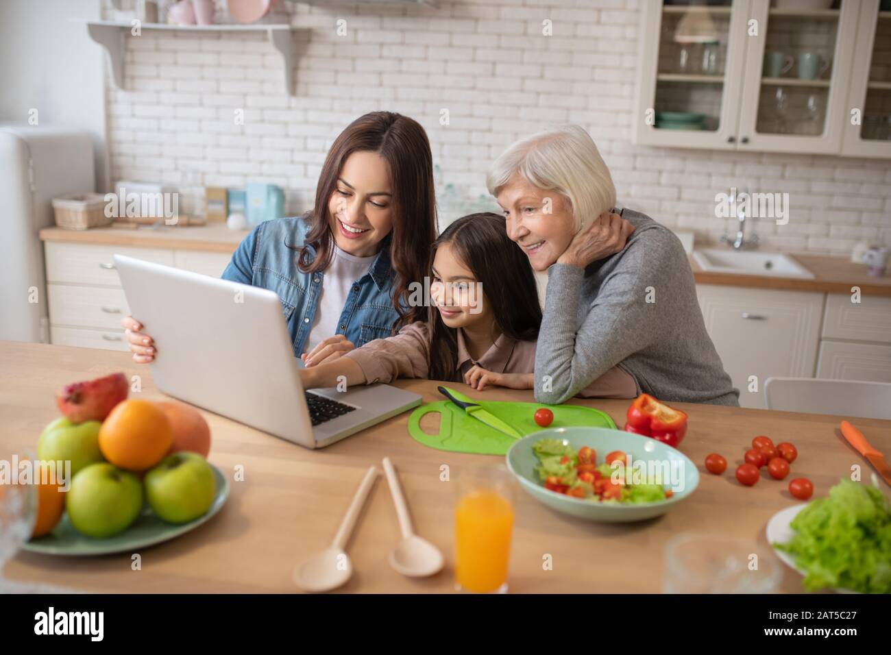 Mutter Tochter Großmutter beobachtet Online-Rezepte auf einem Laptop. Stockfoto