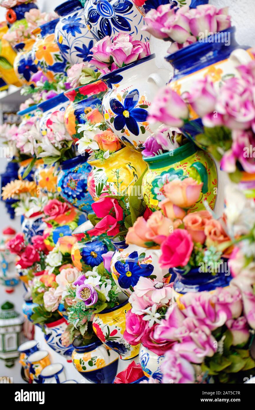 Vertikales Vollbildbild Nahansicht Hintergrund hängend an der Wand dekorative handgefertigte Blumentöpfe mit künstlichen Blumen, Mijas Dorf, Spanien Stockfoto