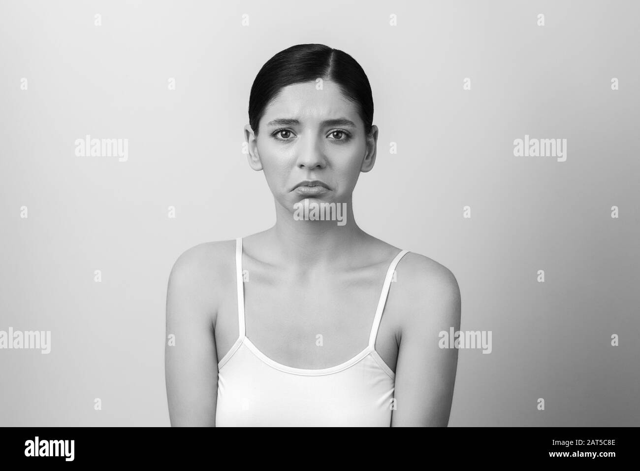 Traurigkeit: Schwarz-Weiß-Porträt einer allein und unglücklich verunglückten Frau. Emotionales Gesicht Stockfoto