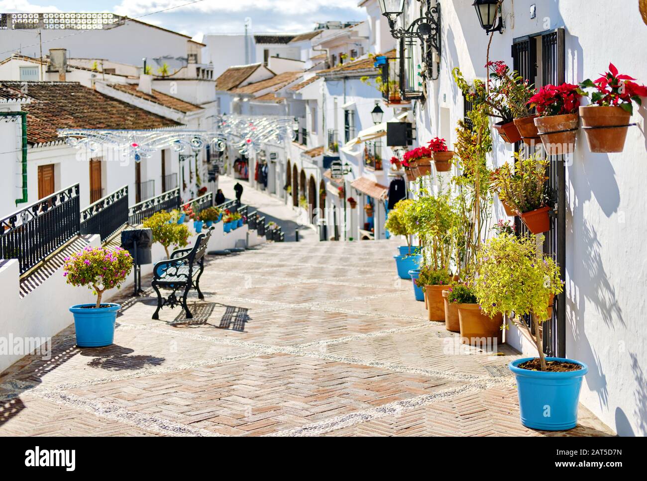 Idyllische malerische Straße kleines weiß gewaschene Dorf Mijas. Weg mit hängen dekoriert an Häusern Wände Pflanzen in hellen Blumentöpfen, Fam Stockfoto