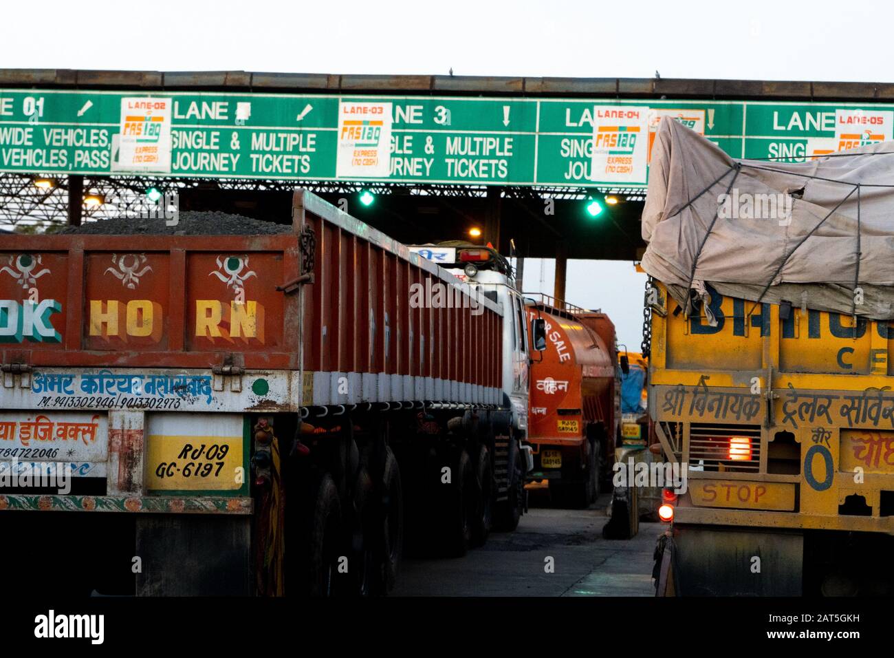 Fahrzeuge, Autos, LKWs warten an einer Mautstelle in Indien auf Barzahlung oder fastag-basierte Zahlung Stockfoto