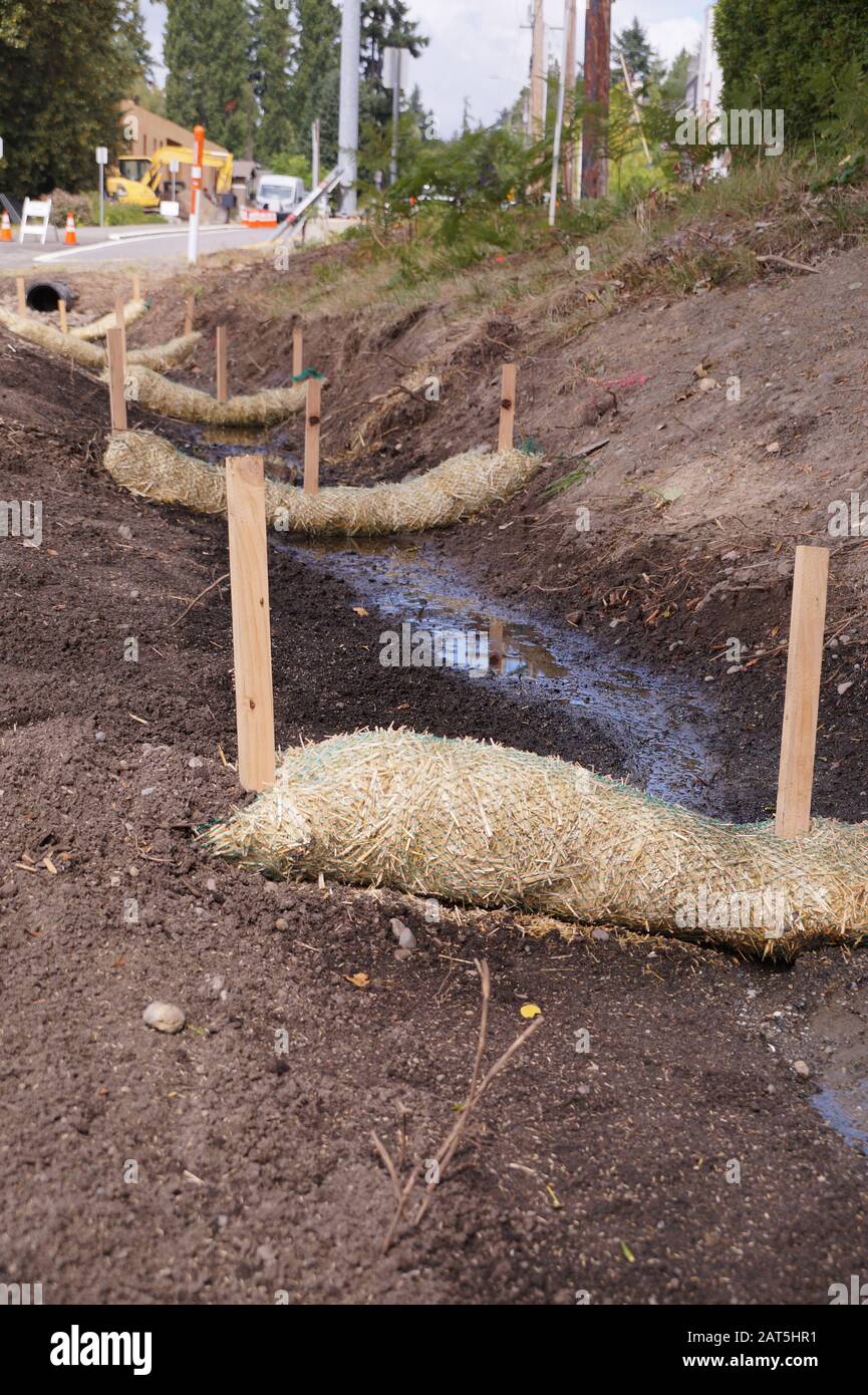 Landabflussarbeiten. Die Verwendung von Strohwatten (Strohwürmer, Biostämme, Strohnudeln). Stockfoto