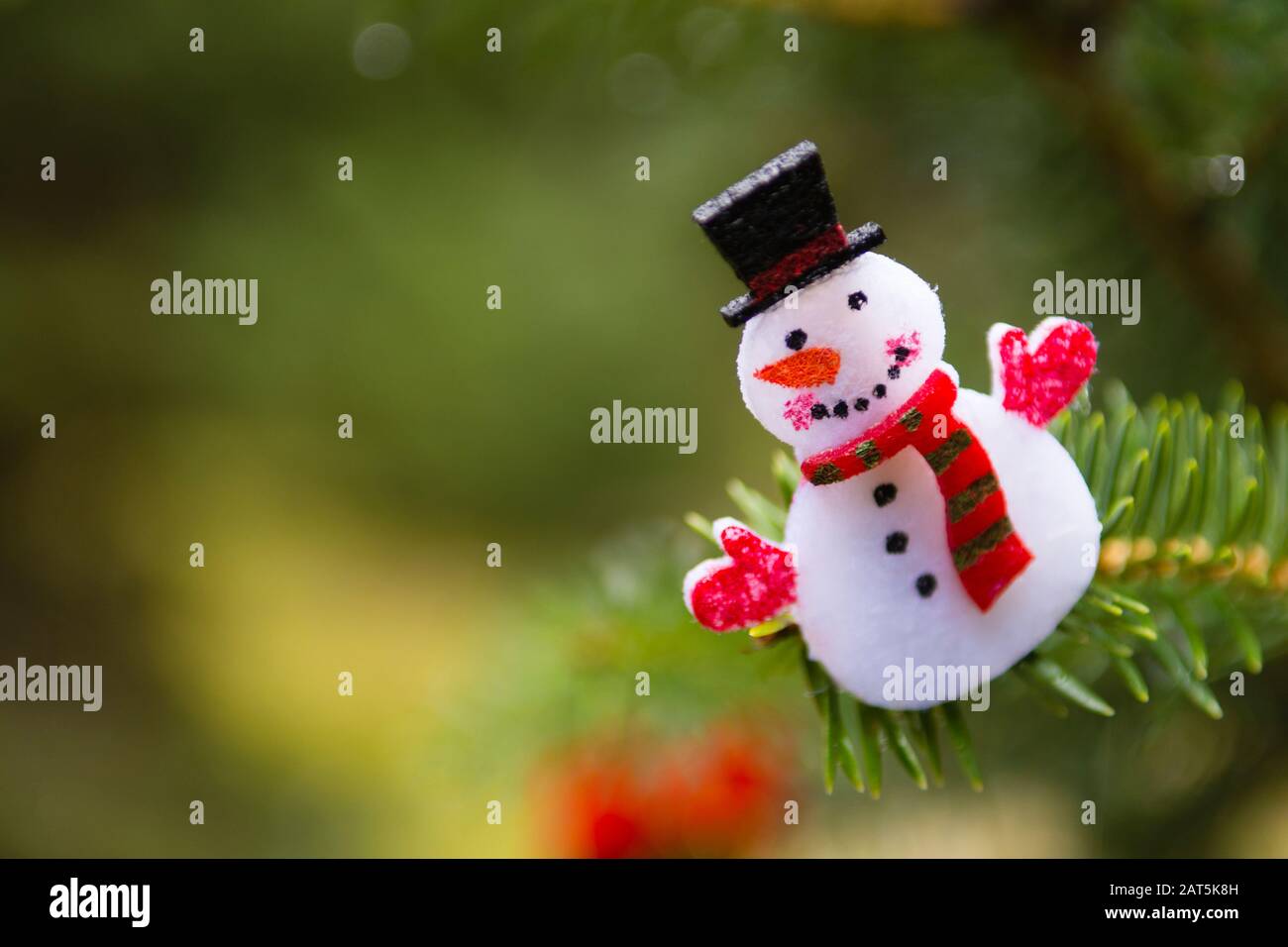 Schneemann, weihnachtsornament, das an einem Kiefernbaum im Freien hängt Stockfoto