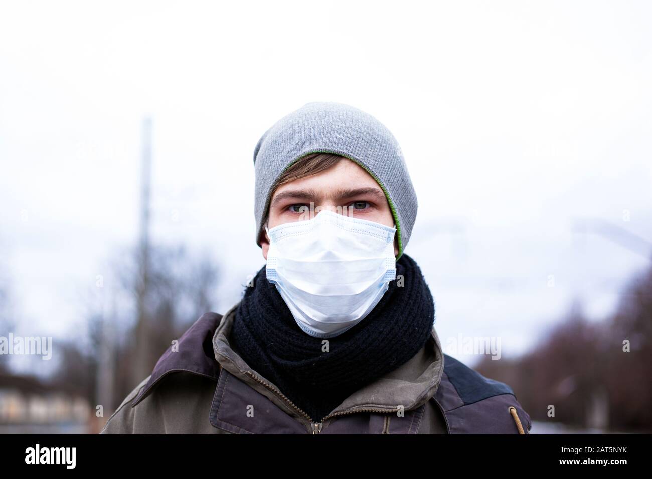 Ein junger Kerl in einer Schutzmaske schützt sich vor Coronavirus, einer Pandemie des chinesischen Virus. Ncov-2019. Stockfoto