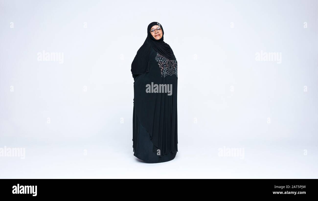 Islamfrau in Burqa steht isoliert auf weißem Hintergrund. Lächelnde islamfrau mit Blick auf die Kamera. Stockfoto