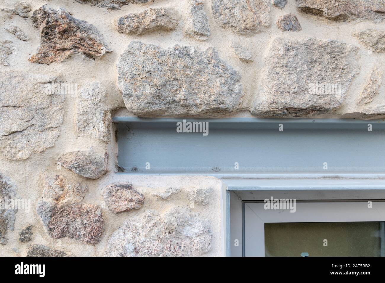 Detail des Eisenbalkens, der als Fensterscheibe wirkt. Sanierung alter Gebäude mit vorhandenen Materialien Stockfoto