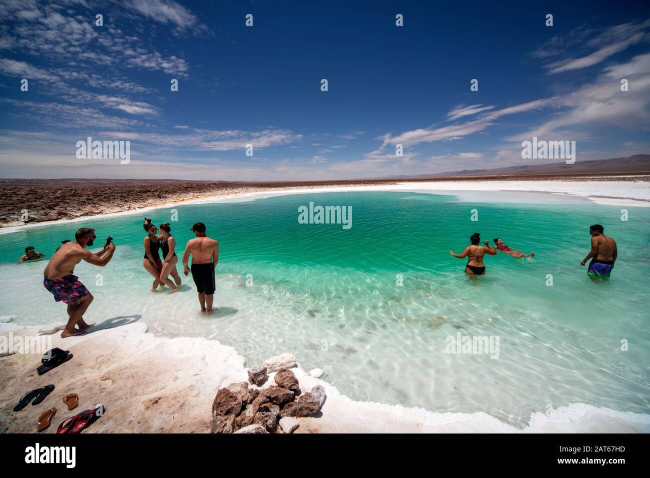 Touristen, die das salzige Wasser der Lagunas Escondidas de Baltinachi, Atacama-Wüste, Antofagasta, Chile, genießen Stockfoto