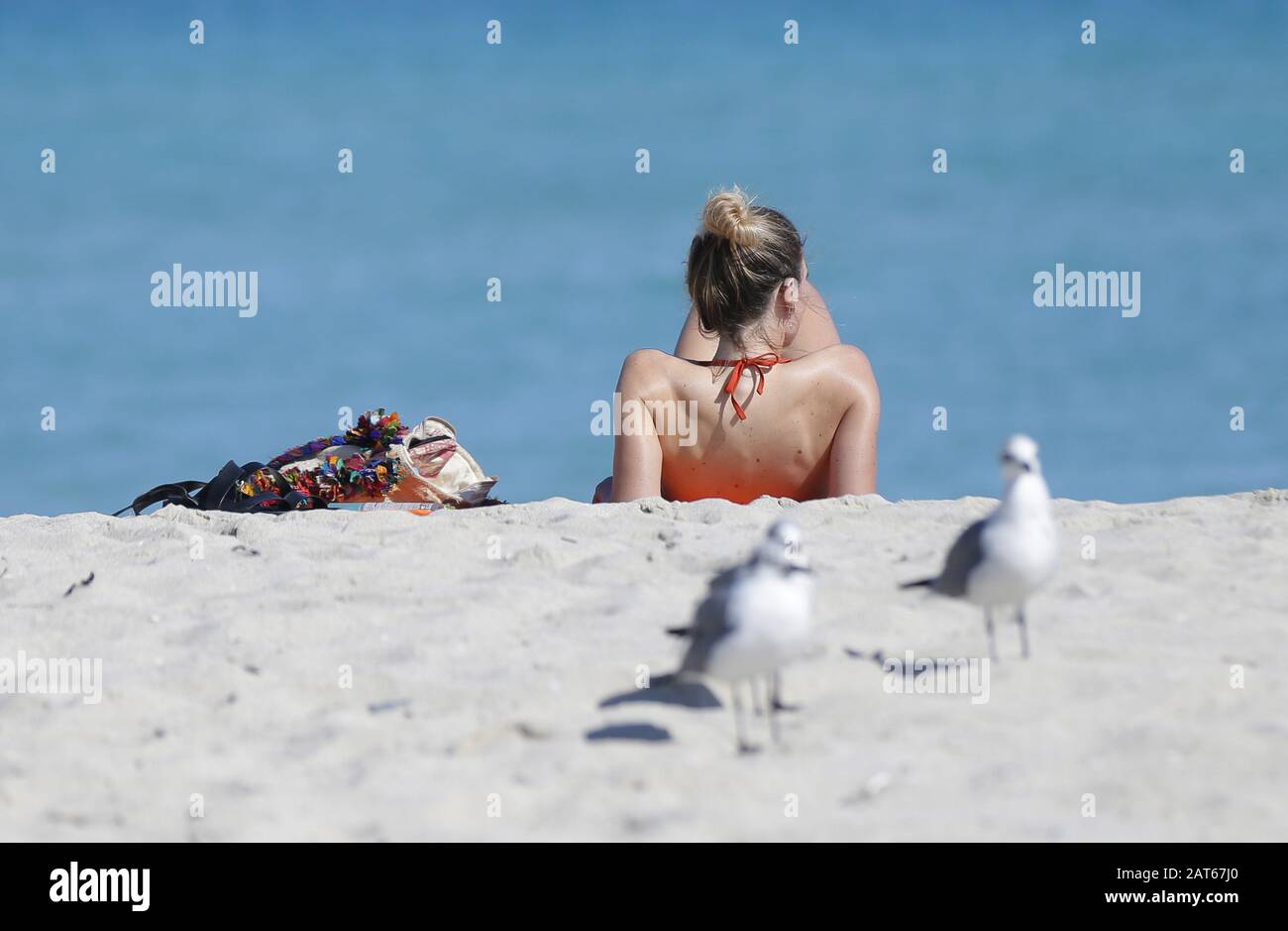 Miami, Vereinigte Staaten. Januar 2020. Eine Frau sitzt am Donnerstag, 30. Januar 2020, in Miami, Florida, im Sand am Miami Beach. Die Kansas City Chefs werden am Sonntag, 2. Februar 2020, die San Francisco 49ers im Super Bowl LIV spielen. Foto von John Angelillo/UPI Credit: UPI/Alamy Live News Stockfoto