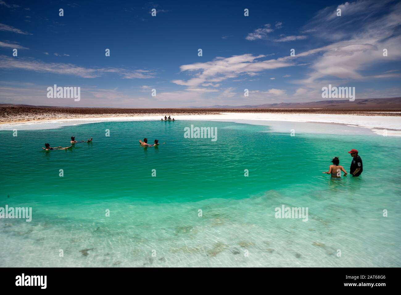 Touristen, die das salzige Wasser der Lagunas Escondidas de Baltinachi, Atacama-Wüste, Antofagasta, Chile, genießen Stockfoto