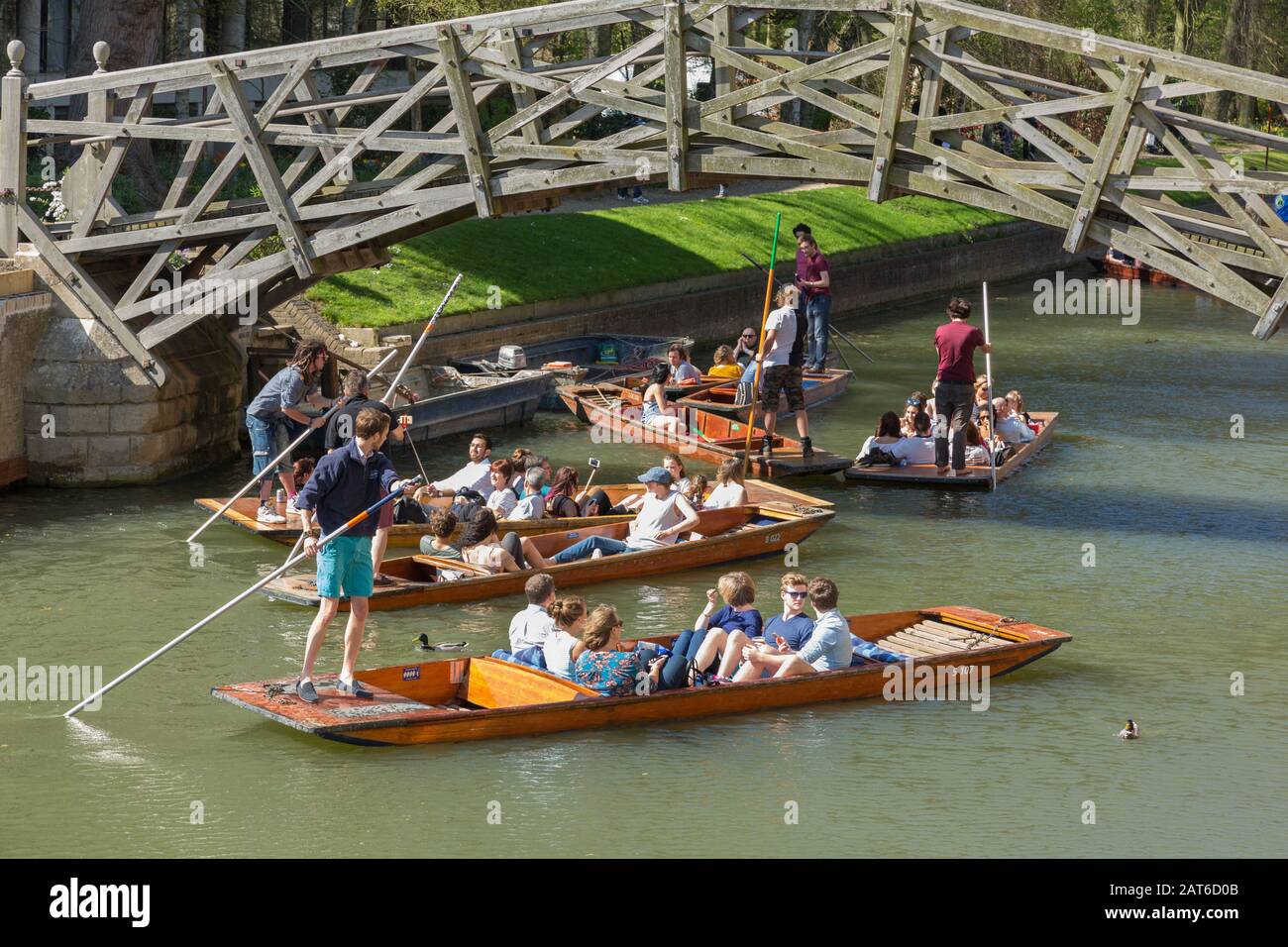 Touristen auf PUNTS auf der River Cam in Cambridge, Großbritannien, die unter der Mathematical Bridge vorbeiziehen Stockfoto