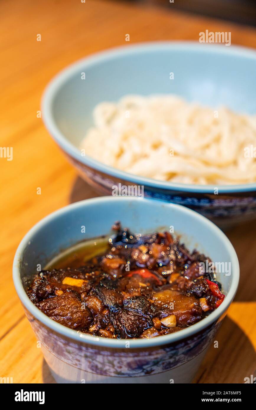 Chinesische Nudeln mit Aubergsauce auf dem Tisch Stockfoto